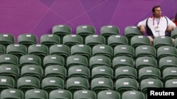 A spectator sits amid empty seats at the All England Lawn Tennis Club during a match at the London 2012 Olympics Games July 28, 2012. 