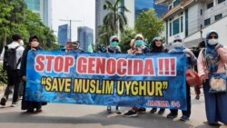 Para demonstran membawa spanduk "Stop Genocida" pada aksi unjuk rasa membela Muslim Uighur di depan Kedutaan Besar Cina di Jakarta (VOA/Fathiyah).