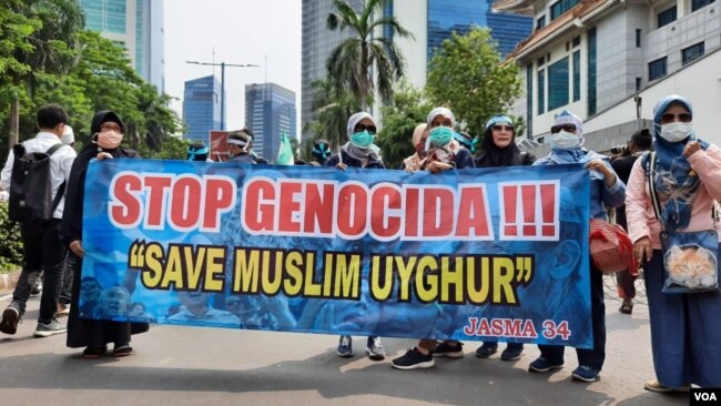 Para demonstran membawa spanduk "Stop Genocida" pada aksi unjuk rasa membela Muslim Uighur di depan Kedutaan Besar Cina di Jakarta (VOA/Fathiyah).
