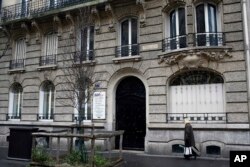 A woman walks past a building on Avenue Parmentier in Paris on Friday, Jan. 25, 2019. The address was supposedly the home of CPW-Consulting.