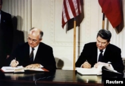 (Ảnh tư liệu) Tổng thống Mỹ Ronald Reagan (phải) và nhà lãnh đạo Liên bang Xô viết Mikhail Gorbachev ký Hiệp ước Các lực lượng Hạt nhân tầm trung (INF) tại Tòa Bạch Ốc, 8/12/1987.
