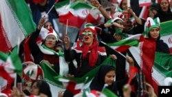 FILE - Iranian women cheer during a soccer match between their national team and Cambodia in the 2022 World Cup qualifier at the Azadi Stadium in Tehran, Iran, Oct. 10, 2019. 