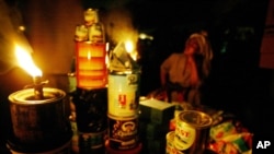 FILE - A street vendor sells her wares by the light of a kerosene wick lamp in Lagos, Nigeria, March 1, 2007.