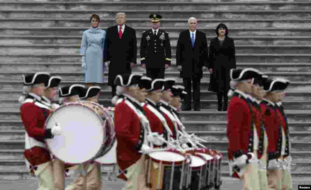 Newly inaugurated U.S. President Donald Trump (in red tie), first lady Melania (L), Vice President Mike Pence and his wife Karen (R) preside over a military parade during Trump's swearing ceremony in Washington, Jan. 20, 2017. 