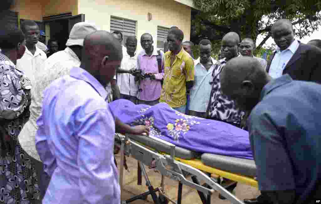 De proches portent sur une civière le corps du journaliste Peter Julius Moi abattu par des hommes armés non-identifiés dans les faubourgs de Juba, 20 aout 2015. (AP Photo/Jason Patinkin).