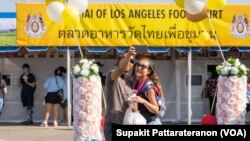 A couple takes a selfie in front of the Wat Thai of Los Angeles Food Court at Wat Thai (Thai Temple) of Los Angeles, North Hollywood, CA. November 06, 2021.