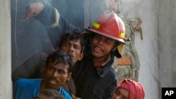 Bangladeshi firefighters and volunteers work to douse a fire at a two-storied garment factory in Dhaka, Bangladesh, January 26, 2013.