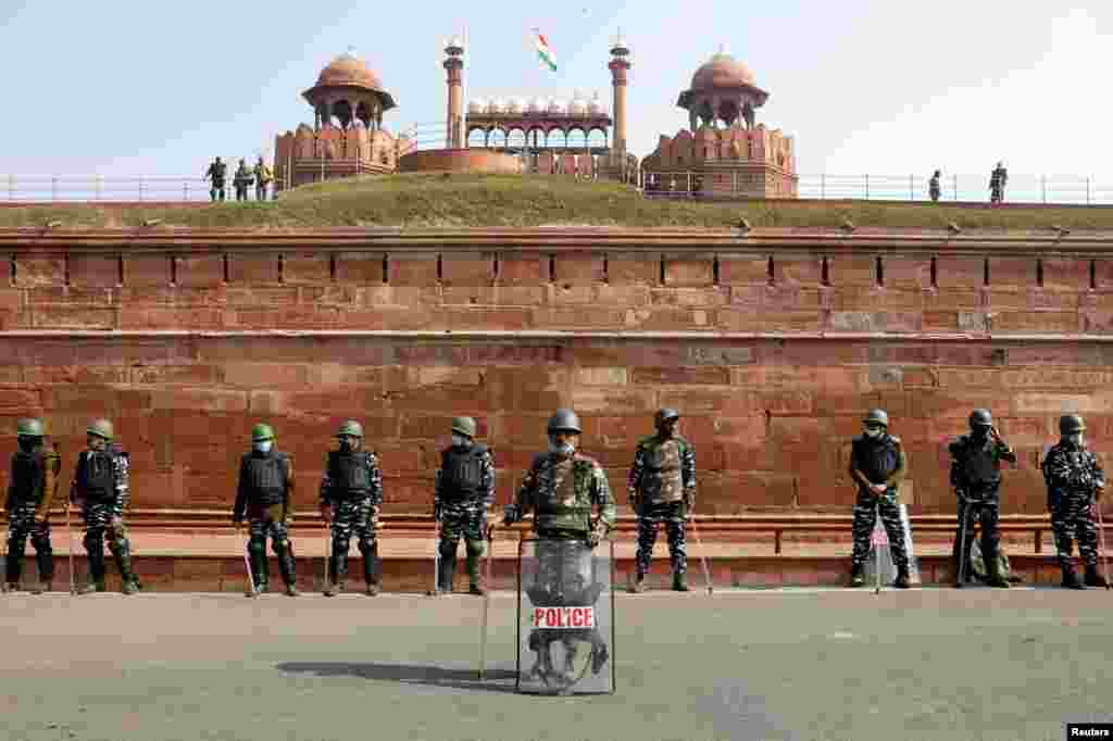 Policemen stand guard in front of the historic Red Fort after clashes took place Tuesday between police and farmers, in the old quarters of Delhi, India.