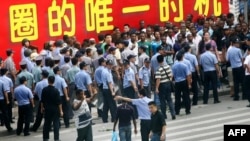 Chinese police face off with a group of Africans blocking the entrance to the police station in Guangzhou, in southern China's Guangdong province, July 15, 2009. 
