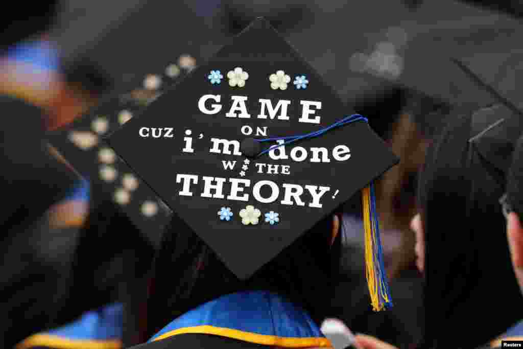 Graduating students place messages and artwork on the top of their caps as they attend their graduating ceremony at UC San Diego in San Diego, California, June 17, 2017.