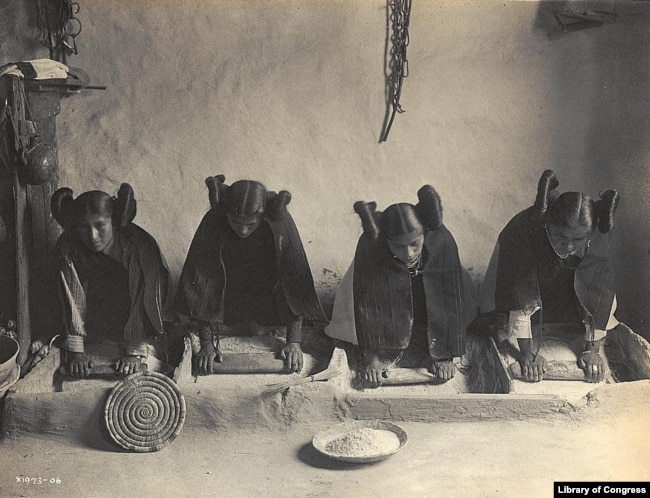 This 1906 photo by Edward S. Curtis shows Hopi women grinding grain into flour.