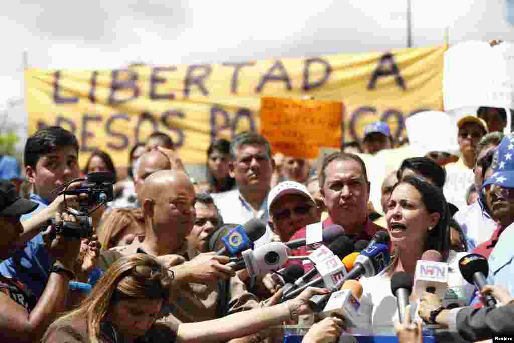 Venezuela&#39;s opposition leader Maria Corina Machado (R) speaks during a gathering in Caracas in support of arrested Mayor Antonio Ledezma. Opposition leaders demanded the release of Ledezma, who was arrested on accusations of plotting violence against President Nicolas Maduro&#39;s government.