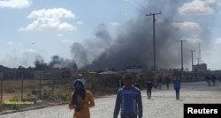 Plumes of smoke are seen behind buildings in Addis Ababa, Oromia, Ethiopia Feb. 13, 2018 in this still image obtained from social media video, Courtesy of TWITTER/@ADDISSTANDAR