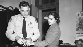FILE - Rosa Parks, whose refusal to move to the back of a bus, touched off the Montgomery bus boycott and the beginning of the civil rights movement, is fingerprinted by police Lt. D.H. Lackey in Montgomery, Alabama, Feb. 22, 1956.