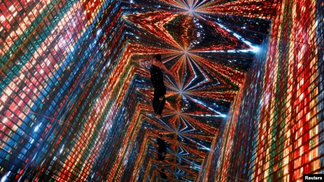 FILE PHOTO: A visitor is pictured in front of an immersive art installation titled "Machine Hallucinations — Space: Metaverse" by media artist Refik Anadol, which will be converted into NFT and auctioned online at Sotheby's, at the Digital Art Fair, in Ho
