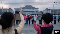 지난 6월 북한을 방문한 중국인 관광객들이 평양 김일성 광장에서 기념사진을 찍고 있다.