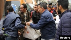 Egipćani pokušavaju da pomognu ambulantnim radnicima da prebace u bolnicu žrtve napada u Aleksandriji, 9. april, 2017. 