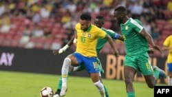 Le Brésilien Neymar et le Sénégalais Salif Sane lors du match de football international amical entre le Brésil et le Sénégal au stade national de Singapour le 10 octobre 2019.