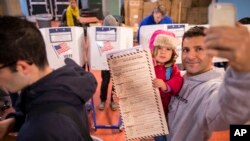 A man takes a selfie with his child as he waits to vote at a polling station in the Brooklyn borough of New York, Nov. 8, 2016.