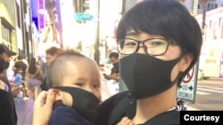 曾经泼墨五星红旗的杨晓女士怀抱名为“普选”的幼子参加10月5日的星光大道挺港行动。