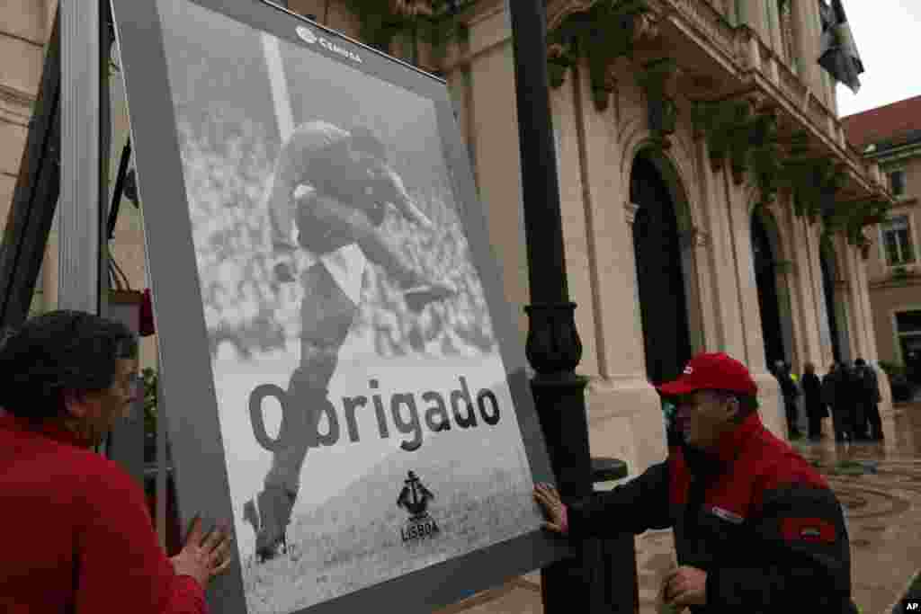 Funcionários da Câmara de Lisboa colocam um poster em honra a Eusébio, agradecendo ao jogador que não resistiu a um ataque cardíaco no domingo, 5 de Janeiro. Milhares de pessoas assistiram ao cortejo fúnebre pelas ruas de Lisboa. Jan. 6, 2014