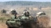 FILE - Belarusian army vehicles drive preparing for war games at an undisclosed location in Belarus, Sept. 11, 2017. Russia and Belarus are holding the annual Zapad war games later this month.