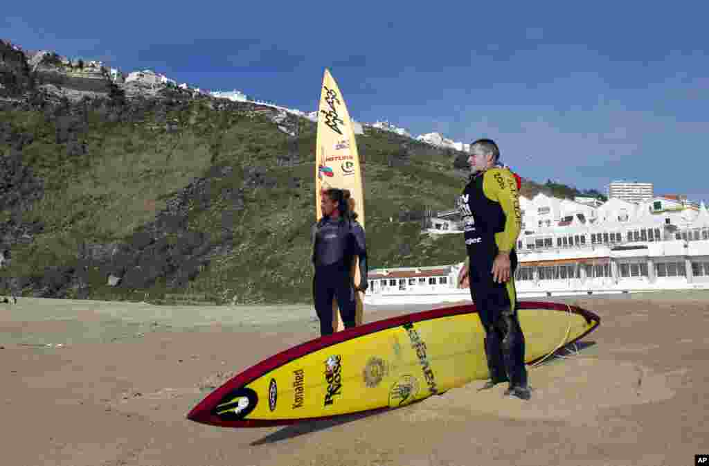 US surfers Garrett McNamara, right, and Kealli Mamala get ready before a surf session at Praia do Norte beach in Nazare, Portugal, Jan. 29, 2013. 