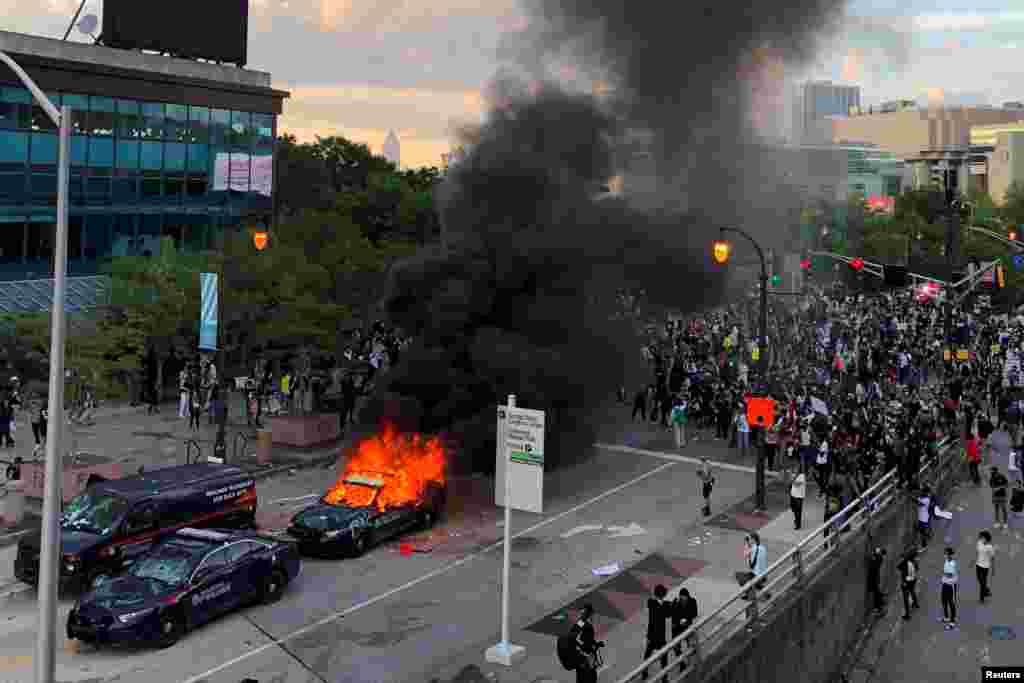 An Atlanta Police car burns as people protest against the death in Minneapolis police custody of African-American man George Floyd, near CNN Center in Atlanta, Georgia, U.S. May 29, 2020. REUTERS/Dustin Chambers TPX IMAGES OF THE DAY