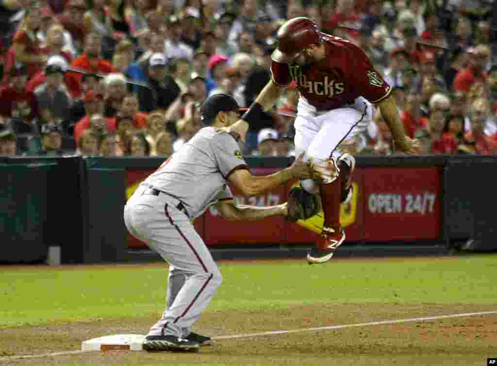 Washington Nationals third baseman Anthony Rendon (6), left, tags out Arizona Diamondbacks Adam Eaton (6) trying to advance on a play in the first inning during a baseball game in Phoenix, Arizona, Sept 29, 2013.