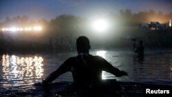 Seorang migran mencoba melintasi sungai Rio Grande di perbatasan AS-Meksiko untuk menuju Texas setelah berhasil mendapatkan perbekalan di Ciudad Acuna di Meksiko pada 22 September 2021. (Foto: Reuters/Danil Becerril)