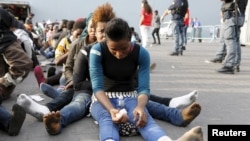 Migrants rest after disembarking from the British assault ship HMS Bulwark at the Sicilian port of Catania after being rescued at sea, Italy, June 8, 2015.