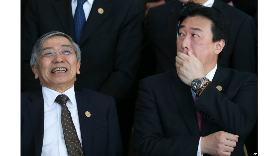 Haruhiko Kuroda, governor of the Bank of Japan, left, and Japan's Vice Finance Minister Minoru Kihara talk before posing for a group picture at the G-20 finance ministers and central bankers summit in Buenos Aires, Argentina, March 19, 2018.