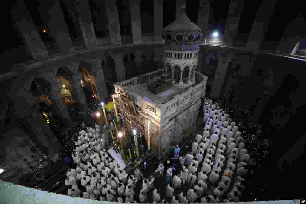 Catholic clergy walk during the Washing of the Feet procession at the Church of the Holy Sepulchre, traditionally believed by many Christians to be the site of the crucifixion and burial of Jesus Christ, in Jerusalem.