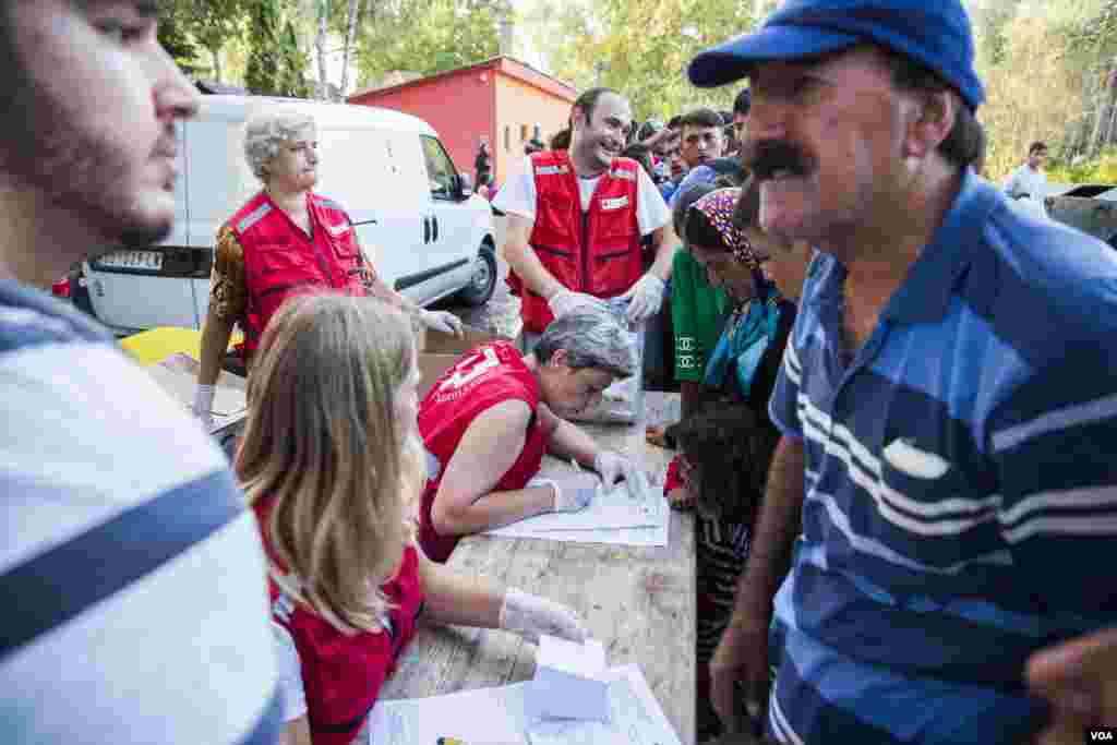 Serbian Red Cross giving food and water to migrants. (A. Tanzeem/VOA)