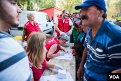 Serbian Red Cross gives food and water to migrants. (A. Tanzeem/VOA)