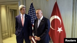 U.S. Secretary of State John Kerry, left, and Turkey's Foreign Minister Mevlut Cavusoglu wait for a meeting in Kuala Lumpur, August 5, 2015. 