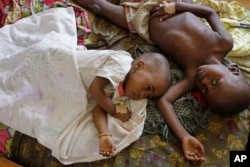 FILE - Two children stricken down with malaria rest at the local hospital in the small village of Walikale, Congo.