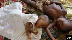 Two children stricken down with malaria rest at the local hospital in the small village of Walikale, Congo.