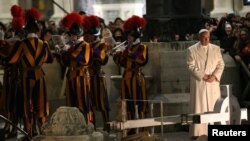 Le pape François se tient près des gardes suisses sur la place Saint Pierre au Vatican, le 31 décembre 2016. 