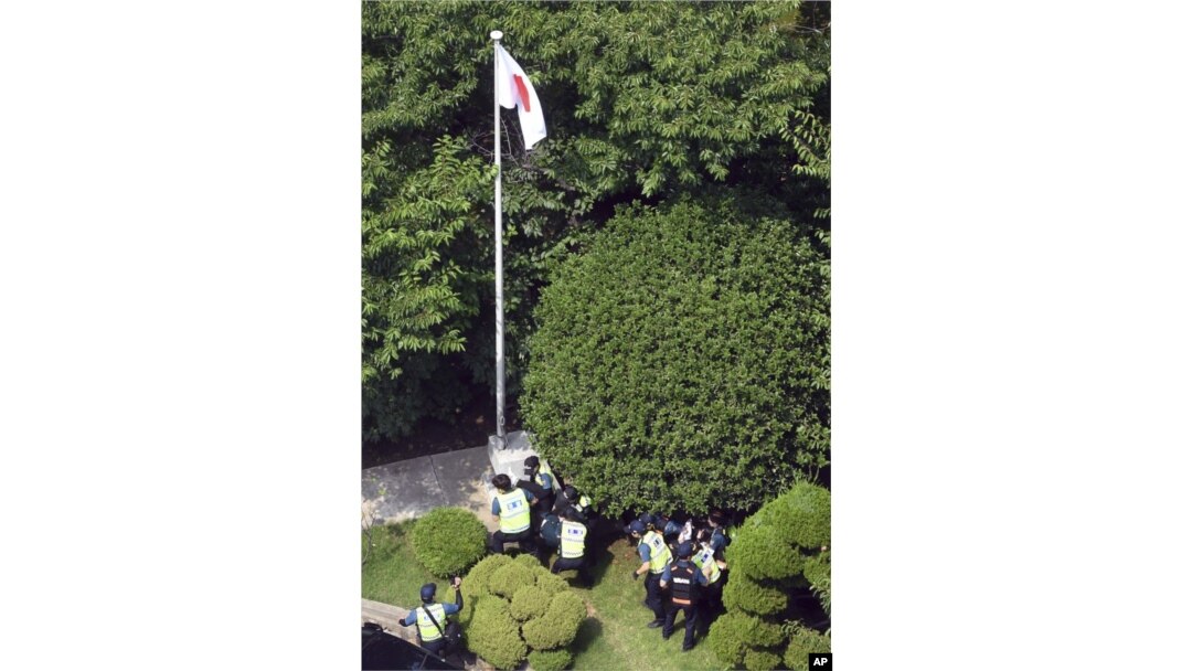 Petugas kepolisian Korea Selatan menahan demonstran di halaman belakang konsulat Jepang di Busan, Korea Selatan, Senin, 22 Juli 2019.