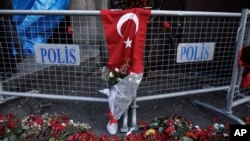 Decenas de flores cubren la acera cercana al lugar donde un atacante mató a 39 personas en un club de Estambul, Turquía, en una fiesta de Año Nuevo. El agresor permanece prófugo.