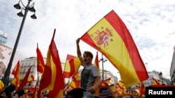 Demonstrators wave Spanish flags during a demonstration in favor of a unified Spain on the day of a banned independence referendum in Catalonia, in Madrid, Spain, Oct. 1, 2017. 