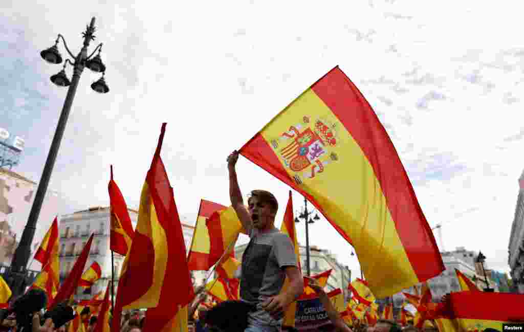 Demonstrators wave Spanish flags during a demonstration in favor of a unified Spain on the day of a banned independence referendum in Catalonia, in Madrid, Oct. 1, 2017.
