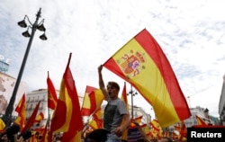 Demonstrators wave Spanish flags during a demonstration in favor of a unified Spain on the day of a banned independence referendum in Catalonia, in Madrid, Spain, Oct. 1, 2017.