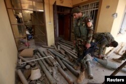 A member of Peshmerga forces inspects a house that was used by Islamic State militants in the town of Bashiqa, after it was recaptured from the Islamic State, east of Mosul, Iraq Nov. 10, 2016.