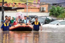 Tim penyelamat mengevakuasi warga yang terkena banjir di Bekasi, Jawa Barat, Rabu (1/1).