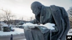 A man walks past a statue of Soviet Union founder Vladimir Lenin installed on the road to the Lenin Hut Museum near Razliv Lake, outside St. Petersburg, Russia, Feb. 25, 2017. In November 2017, some Russians will commemorate 100 years of Bolshevik Revolution. 