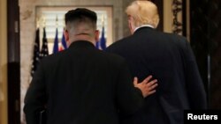 Predsjednik SAD Donald Trump i sjevernokorejski lide Kim Jong odlaze nakon potpisivanja dokumenata kojima je potvrđen napredak u razgovorima i obećano da će se nastaviti naprijed.