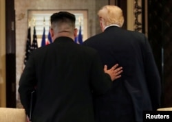 U.S. President Donald Trump and North Korea's leader Kim Jong Un leave after signing documents that acknowledge the progress of the talks and pledge to keep momentum going.