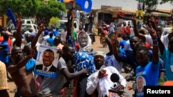 Supporters of Uganda's main opposition presidential candidate Kizza Besigye gesture while standing next to an effigy of him during a Feb. 10 campaign rally in Kampala.